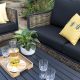 sofa para jardín de ratán roble con detalles en negro y cojines con estampados de diseño